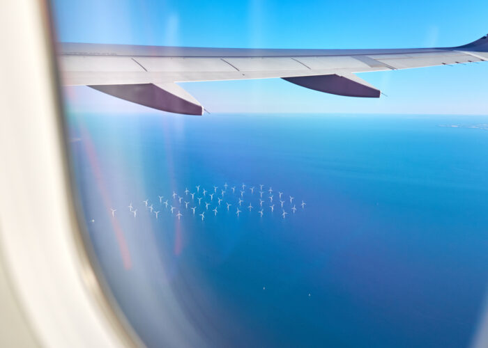 airplane flying over an ocean wind farm