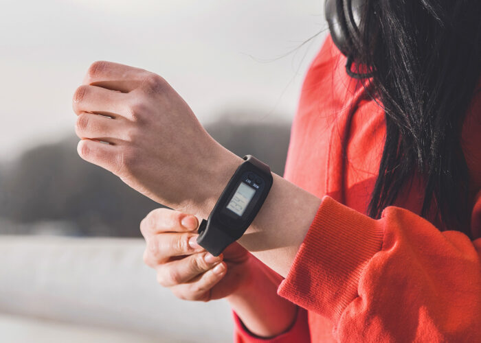 Closeup cropped photo of female runner putting a pedometer on her wrist