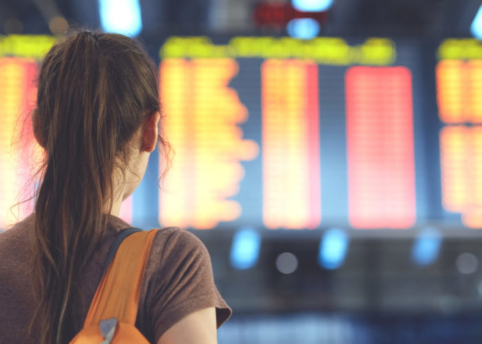 Woman reading departures at departure board