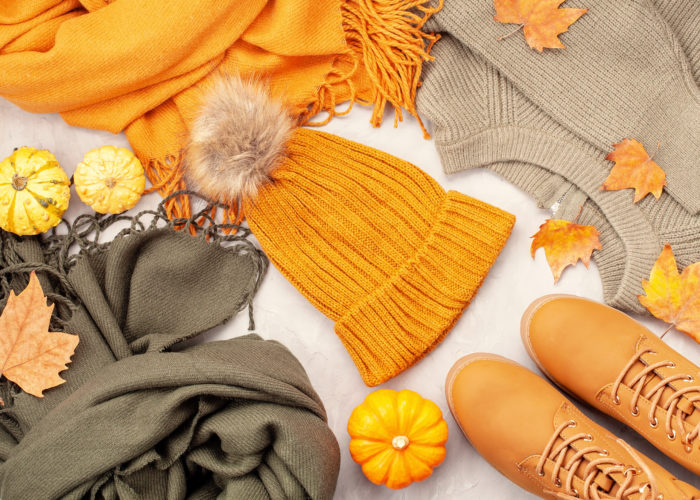 Flat lay with fall clothes, shoes, pumpkins, and leaves