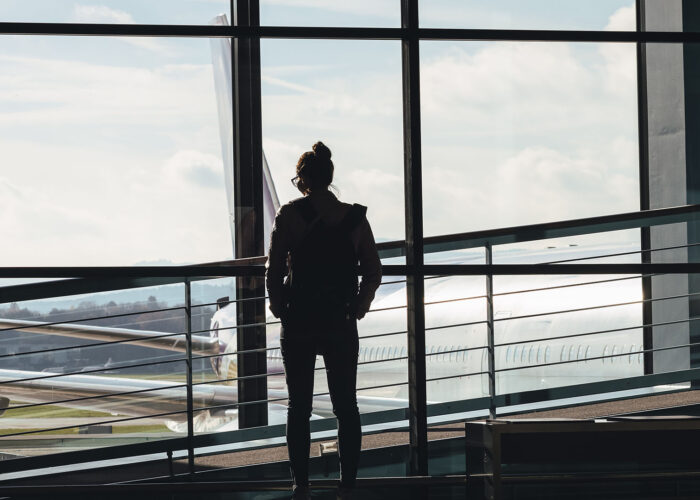 woman looking out airport window.