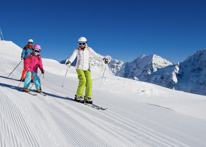 three people skiing down mountain