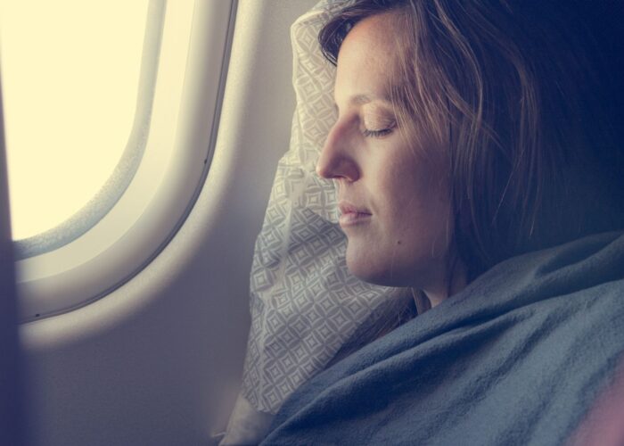 woman sleeping with blanket on plane